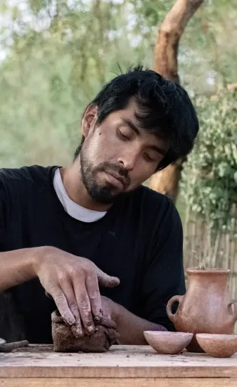 atacameño trabajando con barro para hacer vasijas de barro tipicas de la artesania atacameña