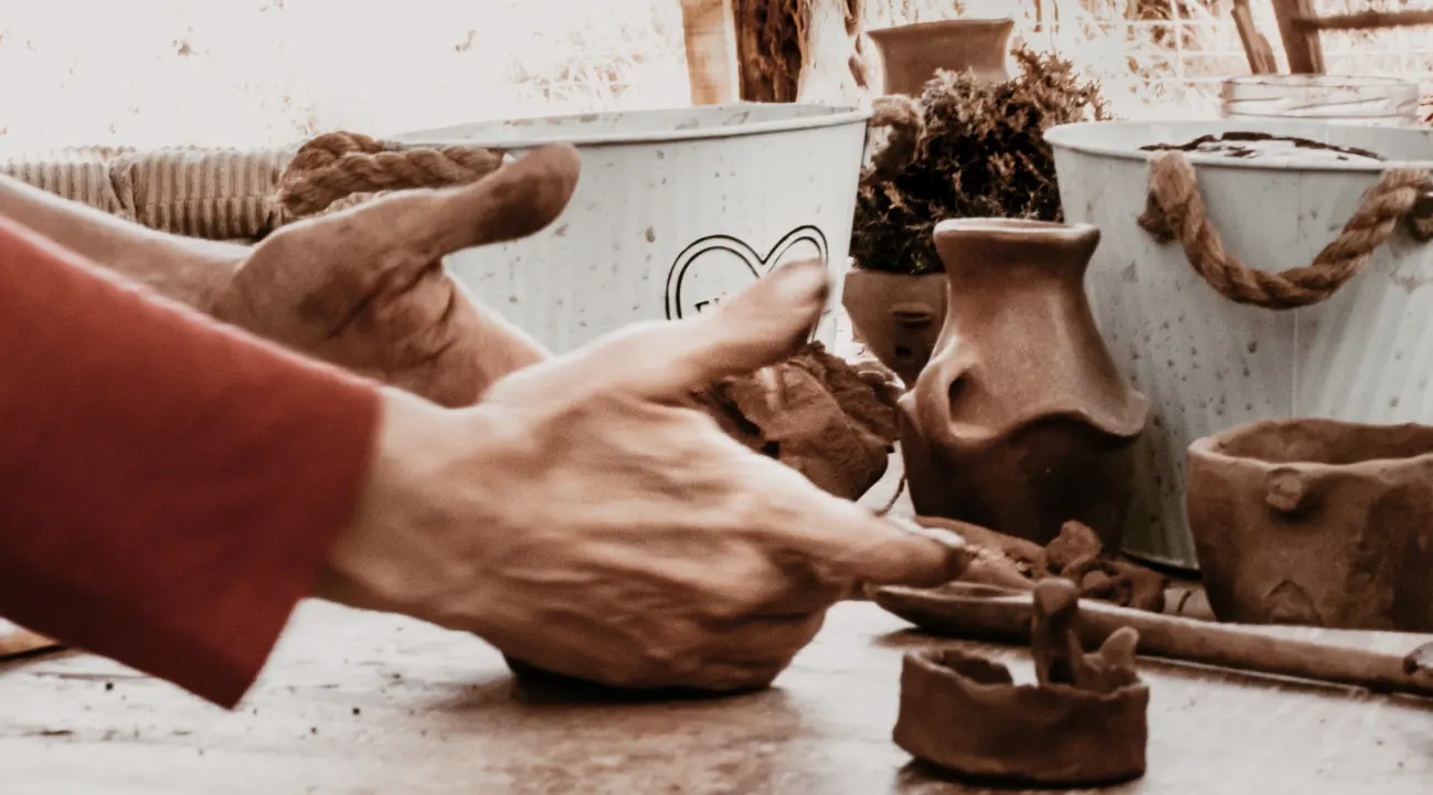 manos de una turista trabajando con barro par hacer artesania en barro tipica atacameña